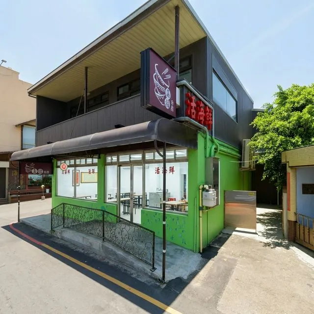 嘉福食堂店面外觀,綠色外牆的二層樓建築,門口掛著「活海鮮」燈箱招牌